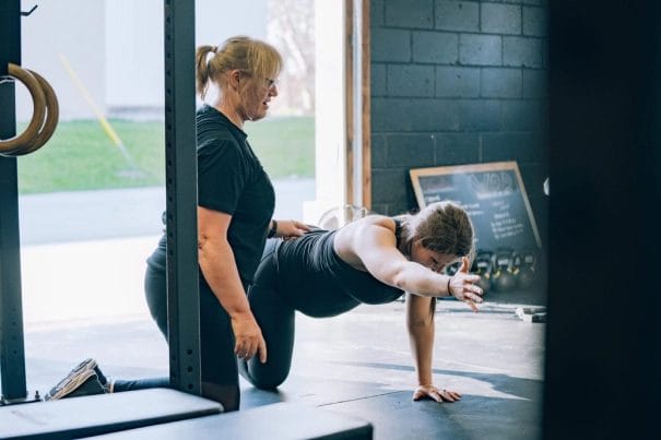 Coach assisting female athlete during personalised semi-private training session at Form Training